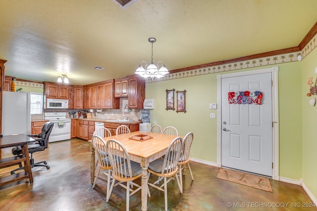 dining area featuring concrete flooring, sink, and a chandelier