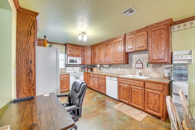 kitchen with a textured ceiling, sink, white appliances, and backsplash