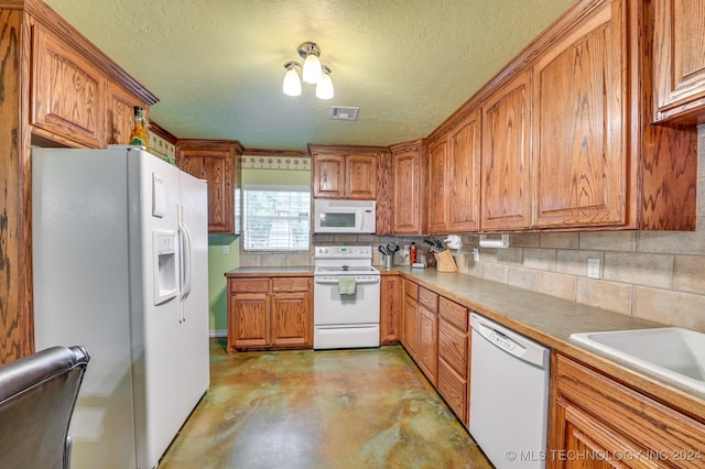 kitchen with tasteful backsplash, a textured ceiling, and white appliances