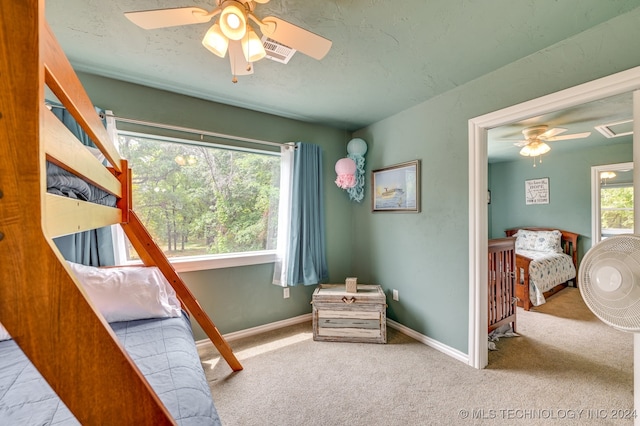 carpeted bedroom with multiple windows and ceiling fan