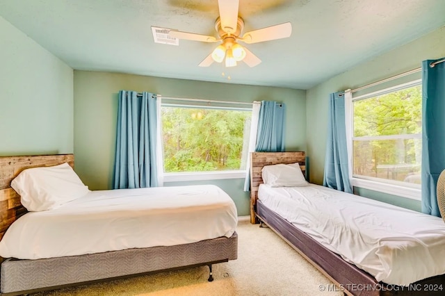 bedroom featuring multiple windows, carpet flooring, and ceiling fan