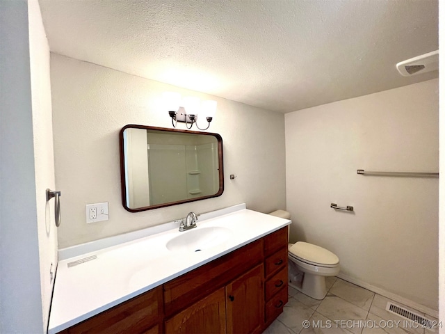 bathroom with vanity, tile patterned floors, toilet, and a textured ceiling