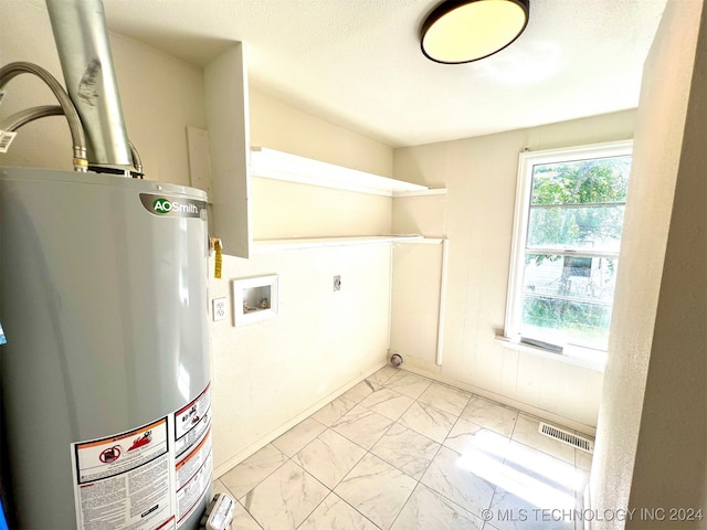 clothes washing area with washer hookup, electric dryer hookup, a textured ceiling, and gas water heater