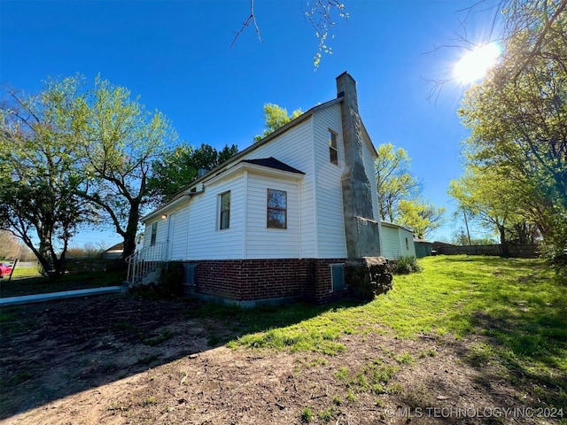 view of side of home with a lawn