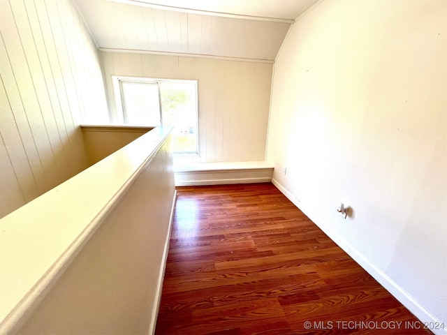 corridor with wood-type flooring and wooden walls