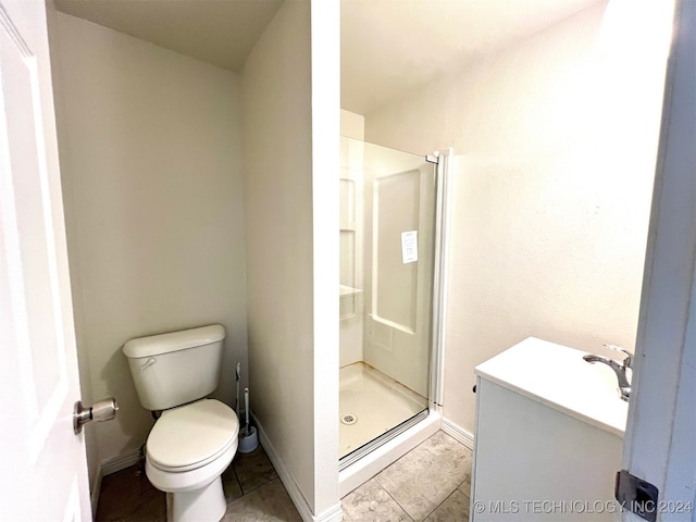 bathroom featuring tile patterned flooring, toilet, an enclosed shower, and sink