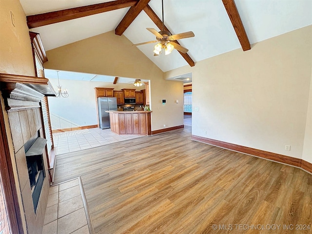 unfurnished living room with ceiling fan with notable chandelier, light hardwood / wood-style floors, high vaulted ceiling, and beam ceiling