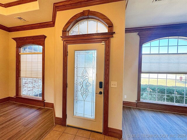 entryway featuring a wealth of natural light, light hardwood / wood-style flooring, and crown molding