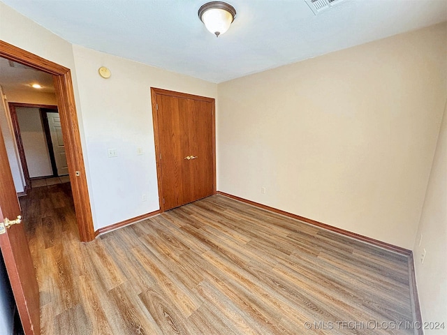 unfurnished bedroom with a closet and light hardwood / wood-style flooring