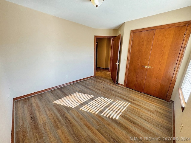 unfurnished bedroom with a closet and light hardwood / wood-style flooring