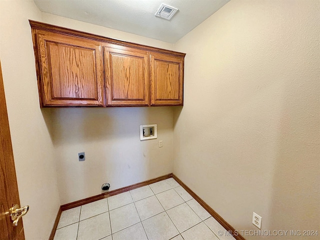 laundry room featuring cabinets, light tile patterned flooring, hookup for a washing machine, and hookup for an electric dryer