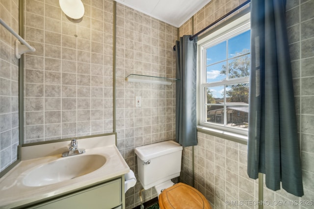 bathroom with vanity, toilet, and tile walls