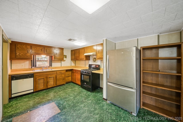 kitchen featuring stainless steel refrigerator, dishwasher, black gas range oven, and sink