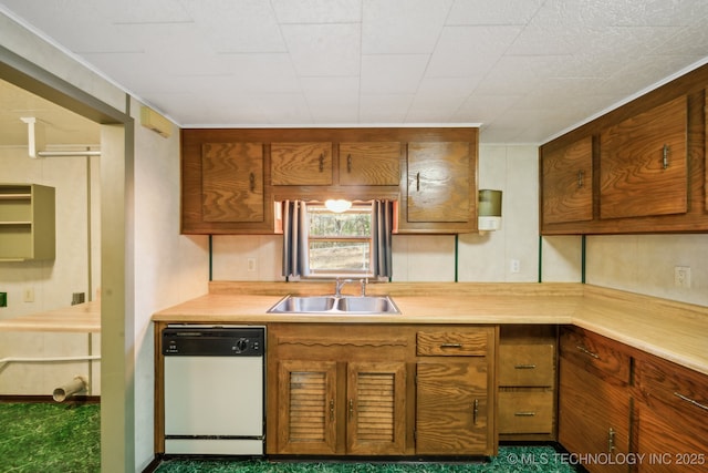 kitchen featuring white dishwasher, dark carpet, crown molding, and sink