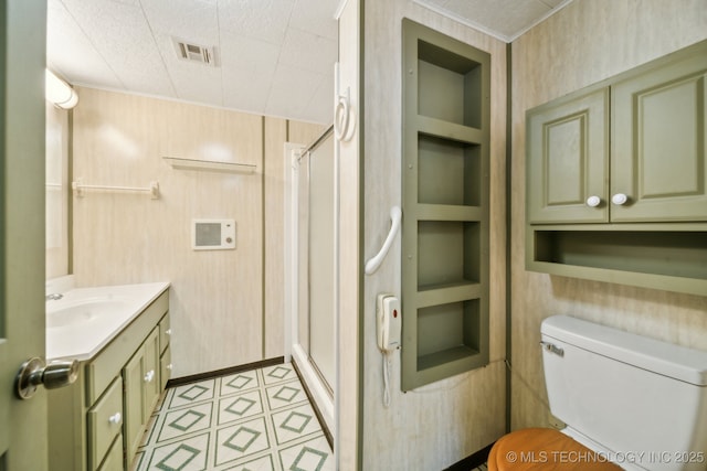 bathroom with toilet, vanity, built in features, and an enclosed shower