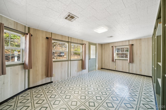 unfurnished room with wood walls