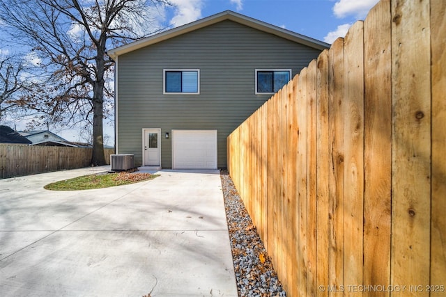 view of home's exterior with a garage and cooling unit