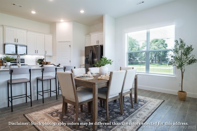 dining space featuring wood tiled floor, visible vents, and recessed lighting