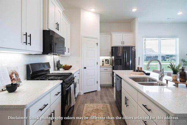 kitchen with dark wood-style flooring, a kitchen island with sink, white cabinets, a sink, and black appliances