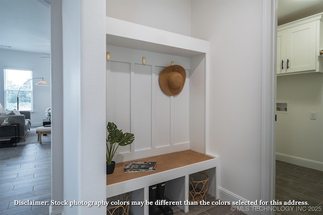 mudroom with dark wood-style floors and baseboards