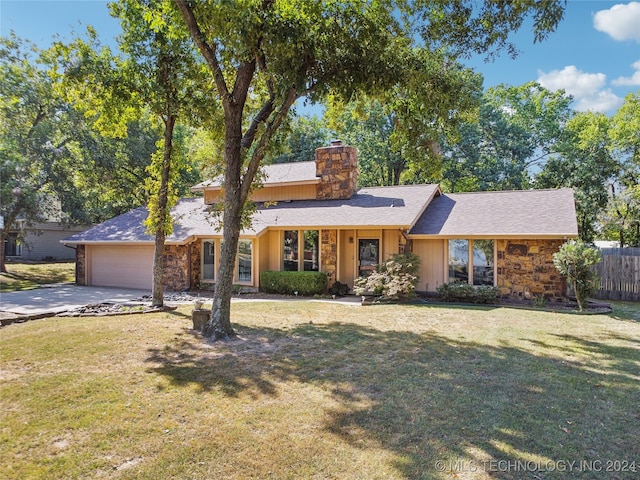 ranch-style home with a garage and a front lawn