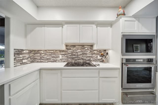 kitchen with backsplash, white cabinetry, and black appliances