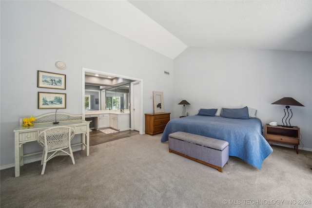 carpeted bedroom featuring ensuite bath and vaulted ceiling