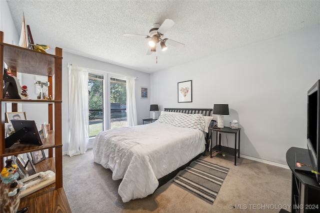 carpeted bedroom featuring ceiling fan and a textured ceiling