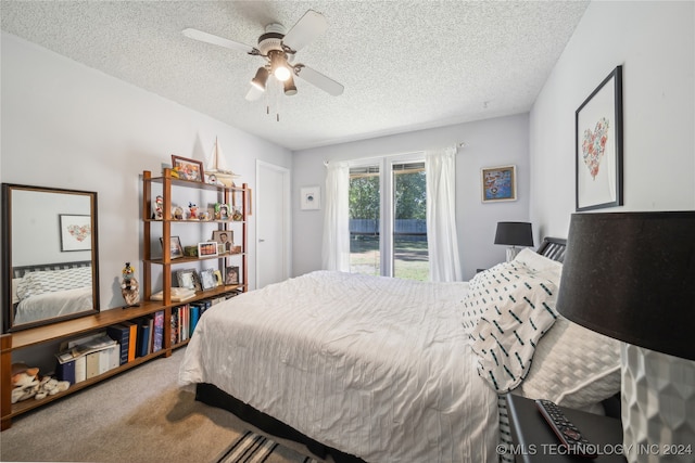 carpeted bedroom featuring ceiling fan and a textured ceiling