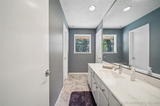 bathroom featuring tile patterned floors, vanity, and a textured ceiling