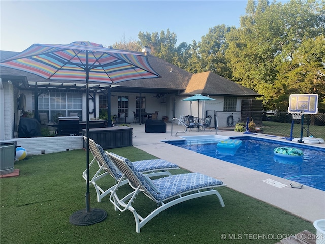 view of swimming pool featuring a lawn and a patio area