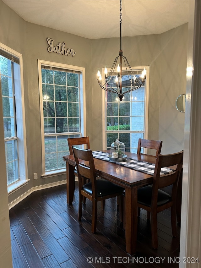 dining space with dark wood-type flooring, a healthy amount of sunlight, and a chandelier