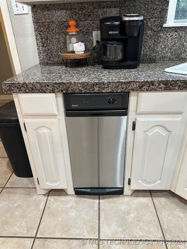 interior details featuring white cabinets, light tile patterned flooring, and tasteful backsplash