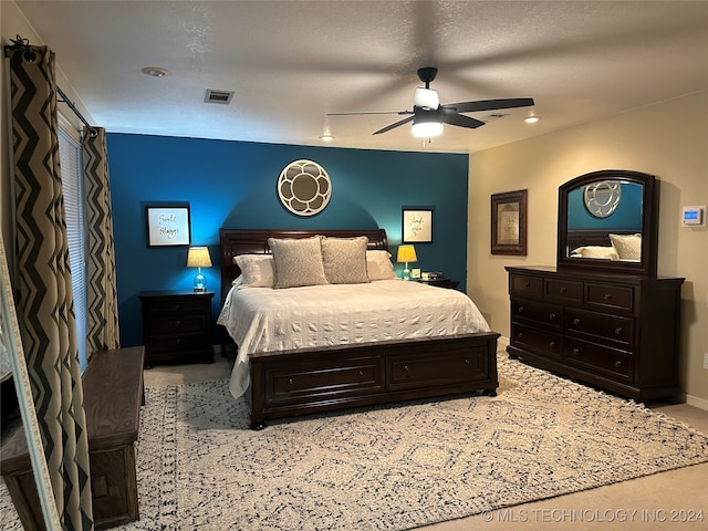 carpeted bedroom with a textured ceiling and ceiling fan