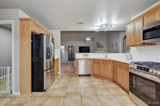 kitchen featuring kitchen peninsula, appliances with stainless steel finishes, light tile patterned floors, and sink