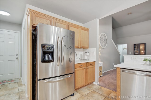 kitchen with backsplash, light brown cabinets, and stainless steel appliances