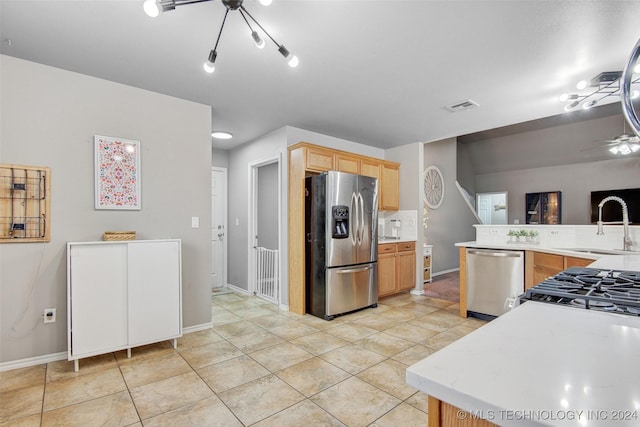 kitchen featuring sink, a notable chandelier, light brown cabinetry, light tile patterned floors, and appliances with stainless steel finishes