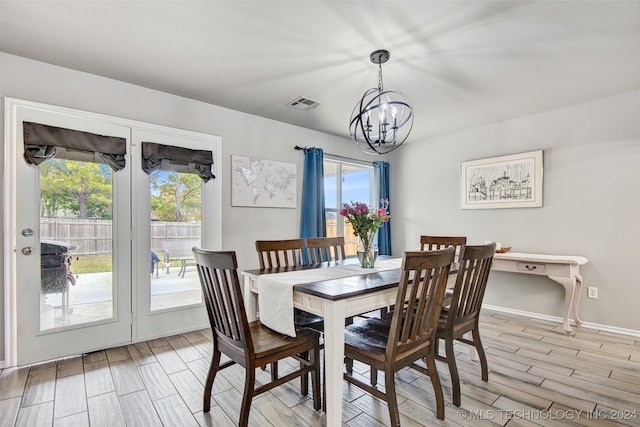 dining room featuring light wood-type flooring and a notable chandelier