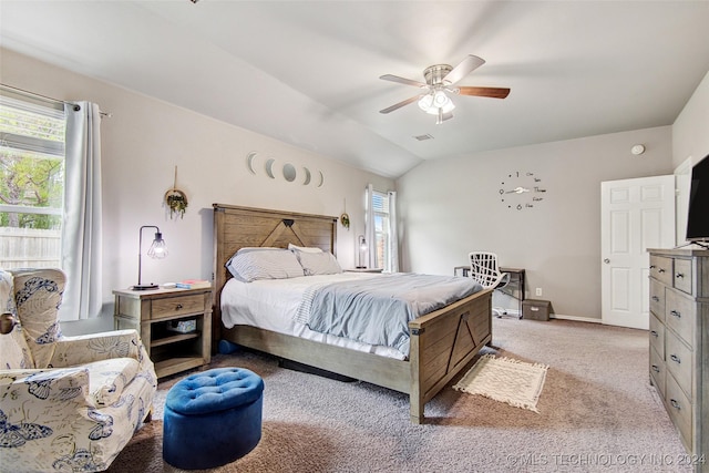 carpeted bedroom with multiple windows, ceiling fan, and lofted ceiling