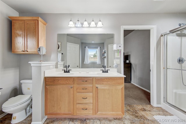 bathroom with vanity, toilet, and a shower with door