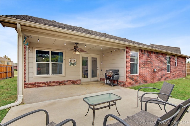 rear view of property featuring a lawn, a patio area, and ceiling fan