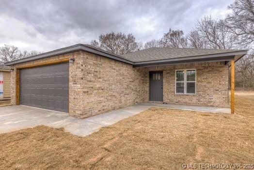 ranch-style home with concrete driveway, brick siding, and an attached garage