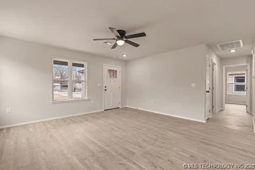 unfurnished room with visible vents, ceiling fan, light wood-style flooring, and baseboards