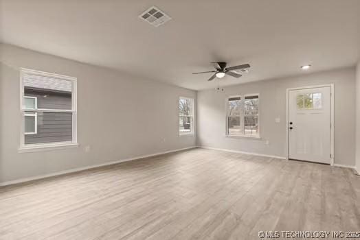 unfurnished living room with ceiling fan, wood finished floors, visible vents, and baseboards