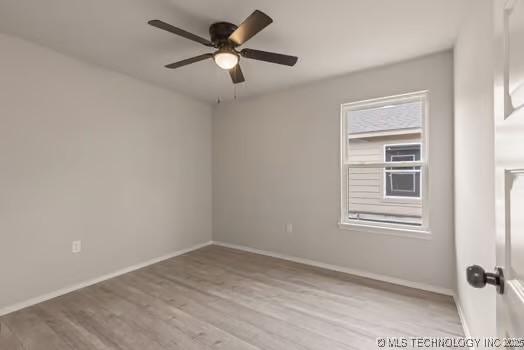 unfurnished room featuring ceiling fan, baseboards, and wood finished floors