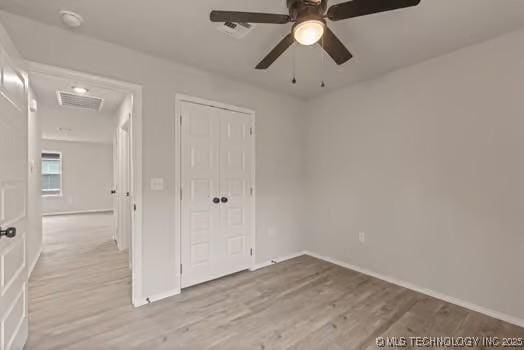 unfurnished bedroom with visible vents, a closet, light wood-style flooring, and a ceiling fan