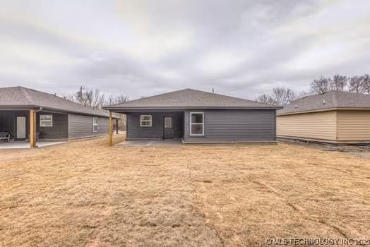 back of house with a yard and a patio