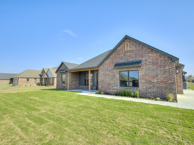 view of front of house featuring a front yard and central AC unit