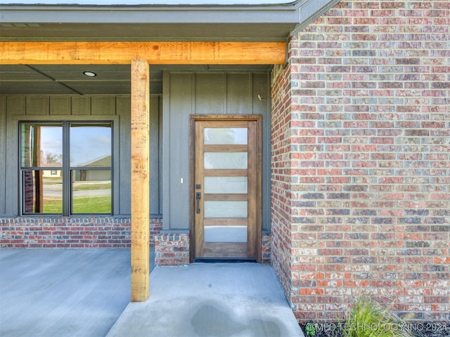 entrance to property featuring brick siding