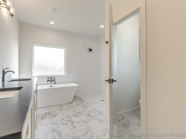 bathroom with vanity, a bathtub, and toilet